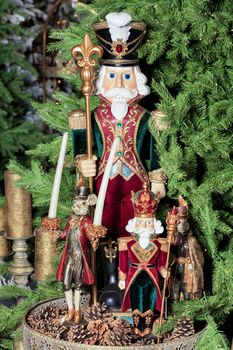 Christmas - New Year's toys and ceramic figures of fairy-tale characters on a background of green spruce branches and cones.