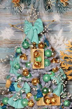 Collection of gold, green and gray balls, Christmas bows and snowflakes, Christmas baubles on silver-gray Christmas tree branches on a wooden aged background. Rat Year 2020 Meeting Concept.