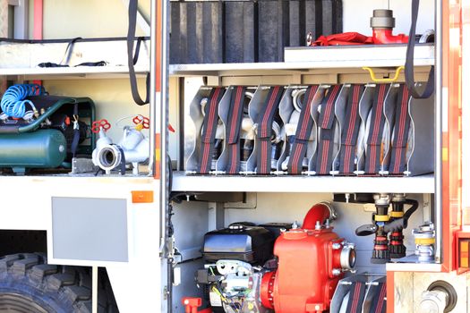 Fire hoses, cranes, hydrants, air compressor, fire pumphigh pressure pump are located in the cargo compartment of an equipped fire truck, free copy space.
