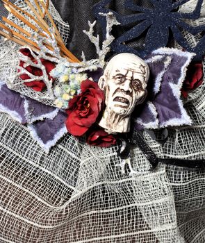 Halloween, decorative white tormented head, skull, spider, web, red flower and various accessories in a single composition for the celebration of Halloween.