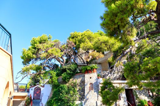 Female Monastery of St. Potapius near Loutraki, Greece against the backdrop of a blue sky and bright green Mediterranean pine, Peloponnese, Greece, August 2019, image with copy space..