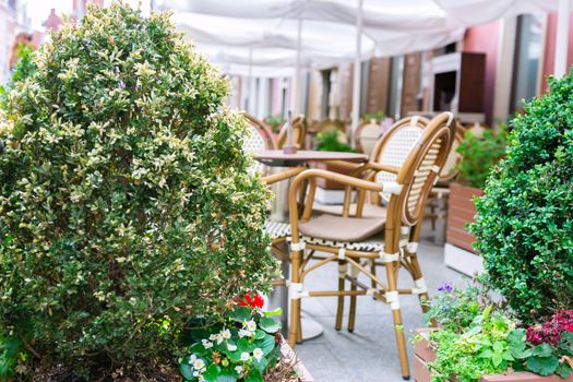 Old fashioned restaurant or cafe terrace located outdoors in a historical city space (selective focus). 