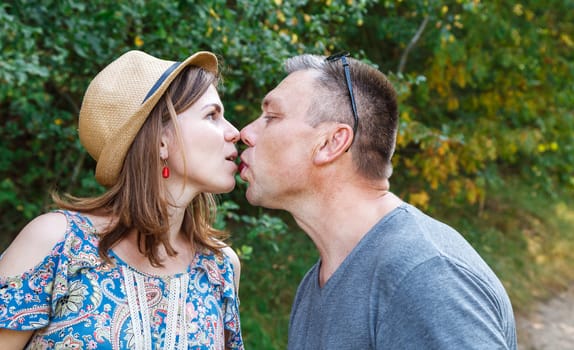 pair of lovers kissing in the forest on sunny summer day