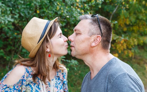 pair of lovers kissing in the forest on sunny summer day