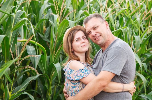 pair of lovers canoodle in the corn field on sunny summer day closeup
