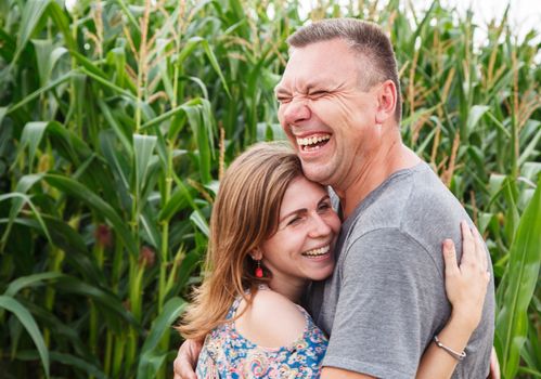 couple of lovers laughing in corn field on sunny summer day