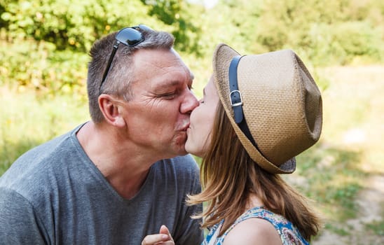 pair of lovers kissing in the forest on sunny summer day
