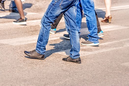 crossroad with walking pedestrians on sunny spring day