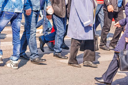 crossroad with walking pedestrians on sunny spring day