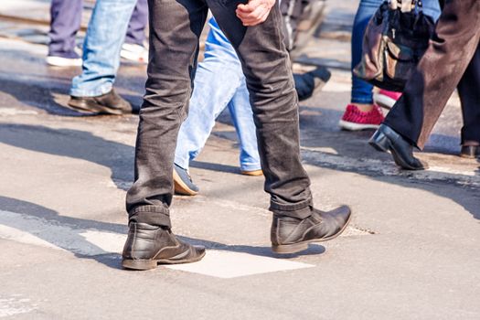 crossroad with walking pedestrians on sunny spring day