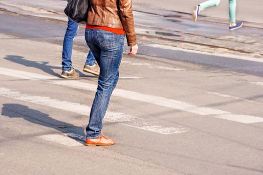 crossroad with walking pedestrians on sunny spring day