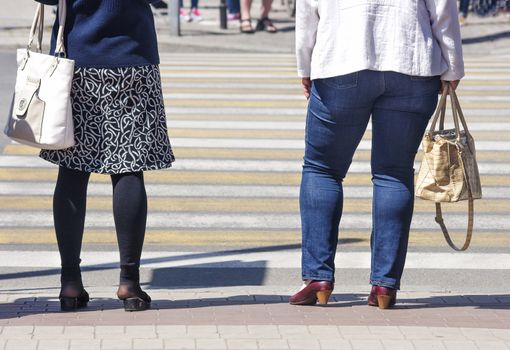 women is waiting to cross the road on sunny summer day