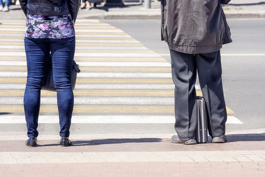 pedestrians waiting to cross street on sunny summer day