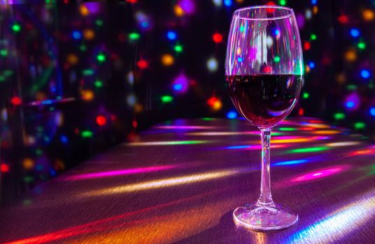 glass of wine on the table in the restaurant with bright festive lighting closeup