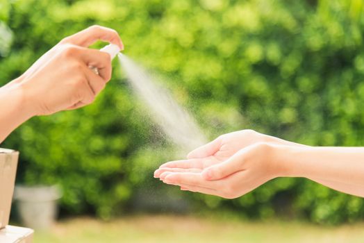 Asian delivery express courier young man use spray sterilize before giving boxes to woman customer receiving both protective face mask, under curfew quarantine pandemic coronavirus COVID-19