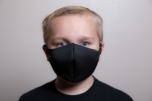 Close up of a young boy wearing a face mask covering