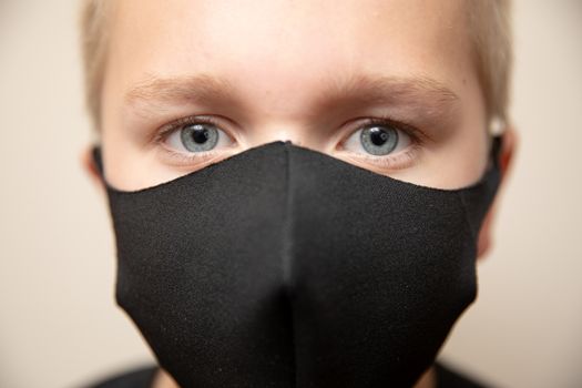 close up shot focused on the eyes of a young boy wearing a face mask