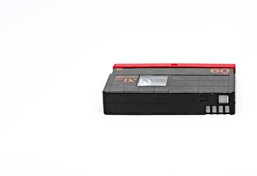side view of a Mini DV format video cassette isolated on a white background. MiniDV cassettes, had been intended for amateur use, but have become accepted in professional productions as well