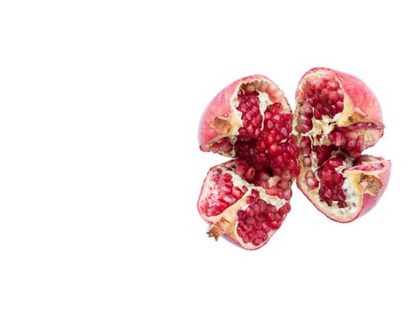Ripe and red pomegranate fruits and divided into four parts, on a white isolated background