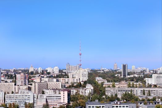 City autumn landscape at noon time with a television tower against the blue sky