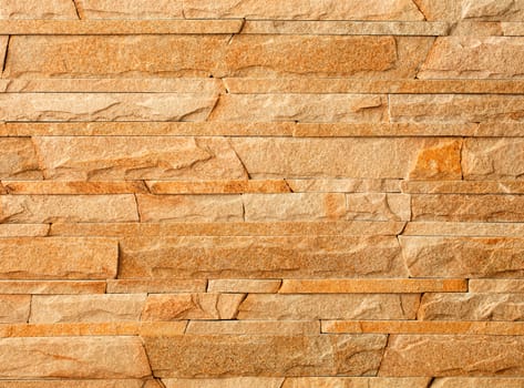 Wall stone mosaic made of golden sandstone texture