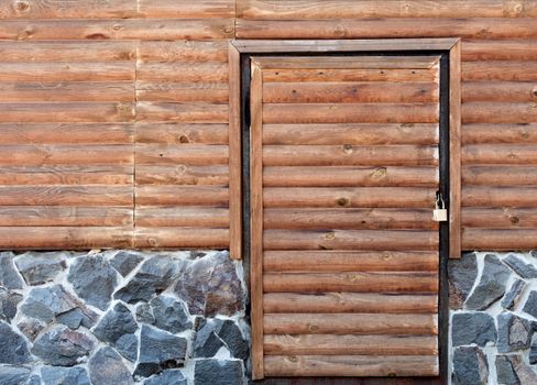 Wooden doors to the back room of the log house and a stone foundation