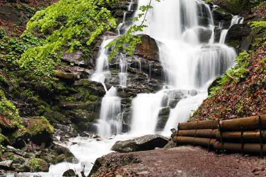 The rapid flow of water falls strongly from the height of the Carpathian mountain.