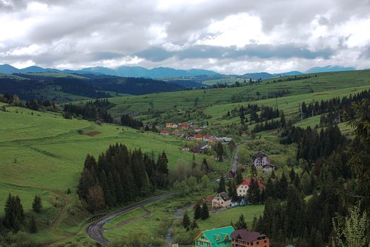 A winding road passes through the village in the valley of the Carpathians.