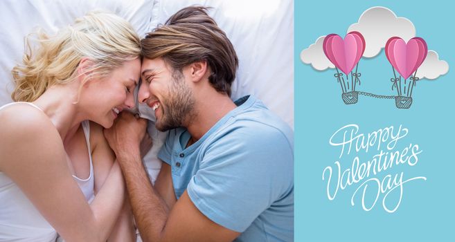 Cute couple relaxing on bed smiling at each other against cute valentines message