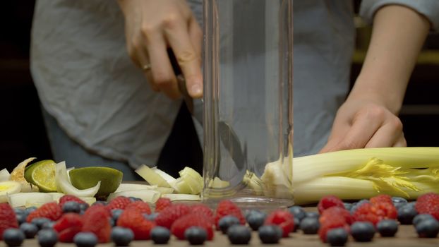 Close up female hands chopping celery. Cooking of smoothies closeup. Healthy lifestyle and eating concept