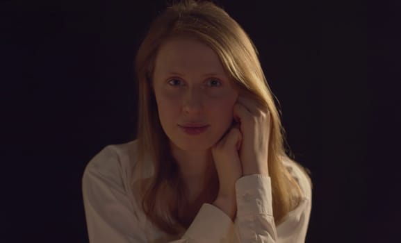 Close up portrait of a young smiling woman on a dark background. Pretty caucasian lady front view