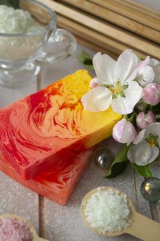 Bar of natural soap with bath sea salt and sakura flowers.