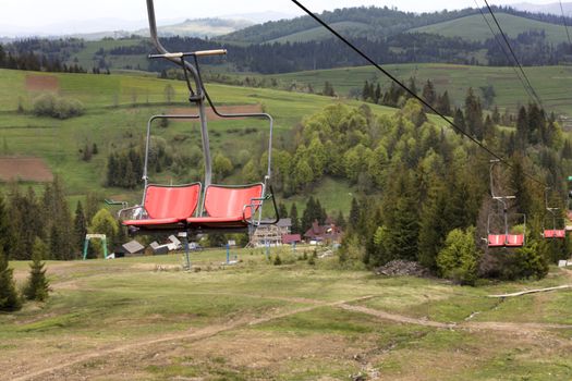 Mountain lift, a row of chairs hang on a moving cable, which is used to transport passengers up and down the mountains.