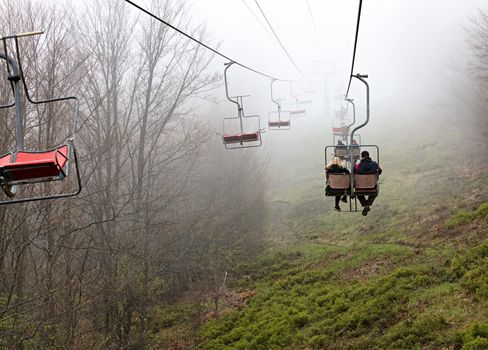 Early in the morning the mountain lift carries tourists to the sleeping mountain, shrouded in fog