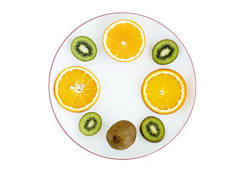 Ripe fruit of orange and kiwi and cut into round slices on a white porcelain plate. Plate with a pomegranate frame on a white isolated background.