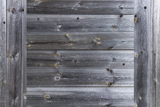 A frame in the form of a weathered old gray wooden fence, which is knocked down by wooden nails, close-up