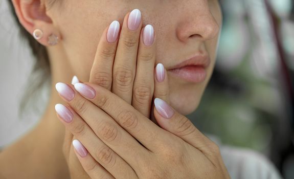 Beautiful woman's nails with beautiful french manicure ombre peach and white