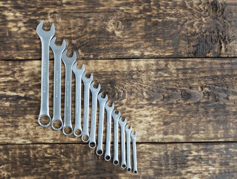set of wrench against old wooden boards background