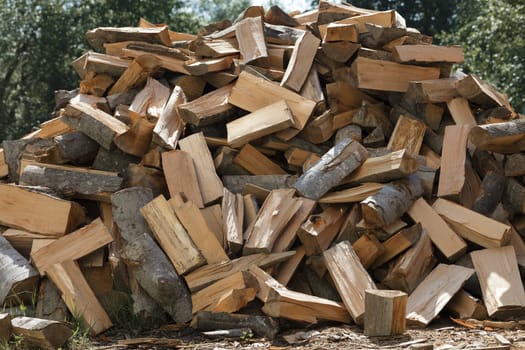 Dry chopped firewood stacked in a pile close up