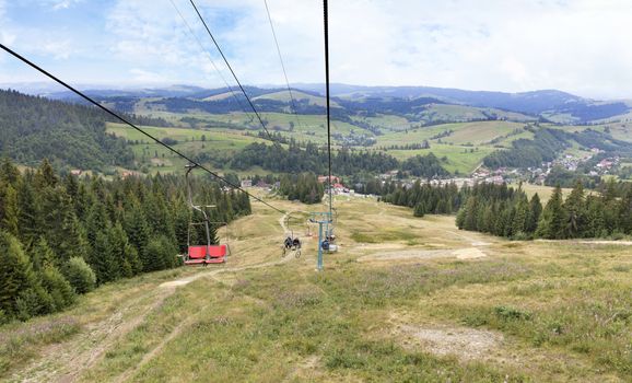 Beautiful mountain landscape of the Carpathian Mountains against the backdrop of a mountain lift carrying tourists