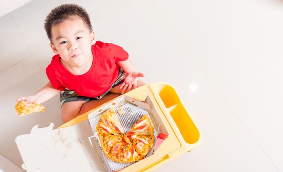 Hot Homemade, Vegetarian fast Italian food, Top view of Cute Little Child enjoying eating Delivery Pizza pepperoni, cheese many slices deliciously in a cardboard box at home with copy space for text