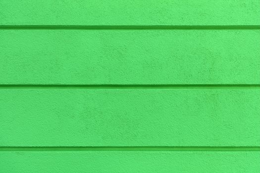Concrete wall texture with colored bright greenlaster. Construction coat-plaster made of insulated material on the wall with horizontal dividing grooves.