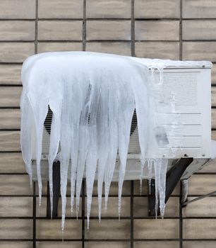 the external unit of the air conditioner is covered with large icicles. Incorrect use of the air conditioner and poor thermal insulation leads to the formation of icicles.