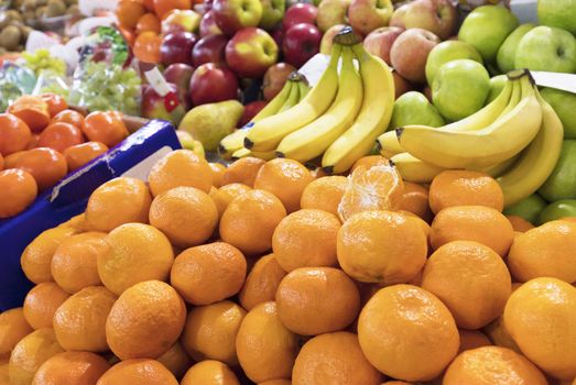 Bright background of fresh fruits. mandarins, bananas, apples lie in the trays in the market and attract attention.