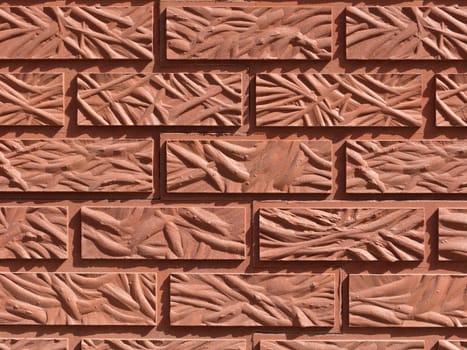 Orange-red brick wall background close-up made of original figured brick