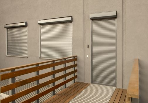 Light brown metal blinds on the doors and windows of the house