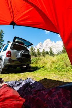 Tent and Off Road Car in Mountains. View From Tent. Outdoor Adventure.