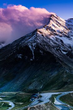 Dramatic Sunset at Snowy Mountains Peaks and High Alpine Road.