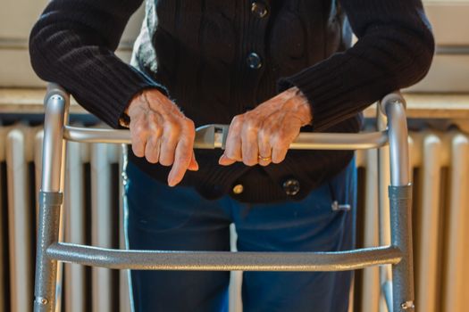 an old woman uses a walker because she has a mobility problems