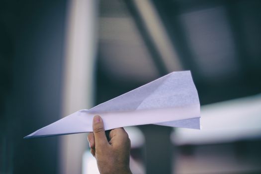 Photograph of a human hand with a paper plane